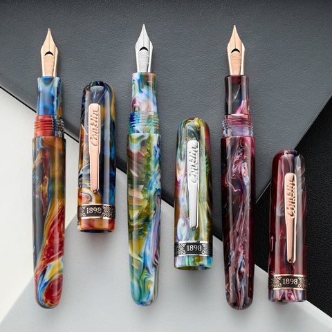 Conklin fountain pens with colorful swirled barrels and gold nibs in a close up.