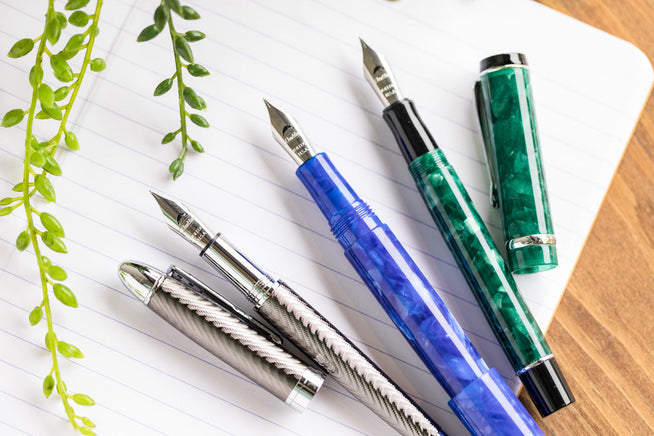 Conklin & Monteverde Pens uncapped on white lined paper