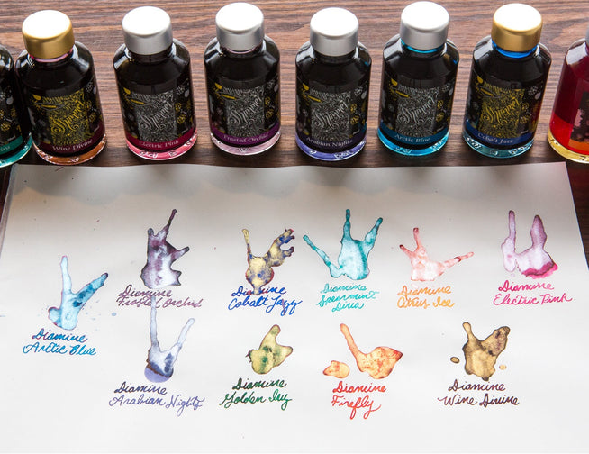 10 Diamine Shimmertastic ink splatters with the bottles