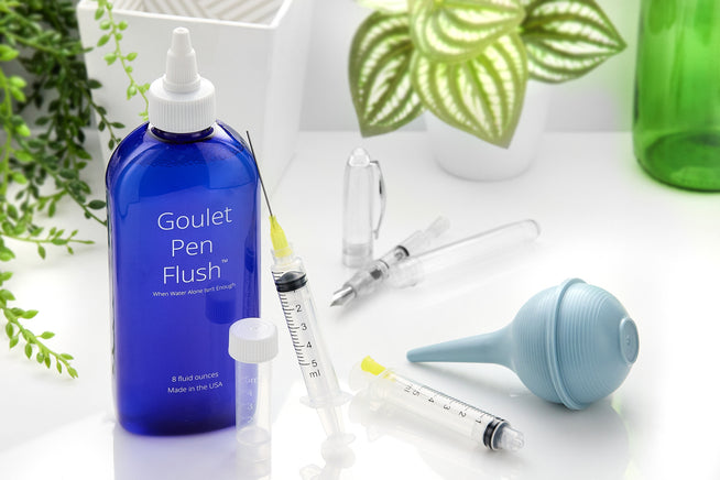 Goulet Pens Pen Flush, ink syringe, bulb syringe, empty ink vial, greenery and plants