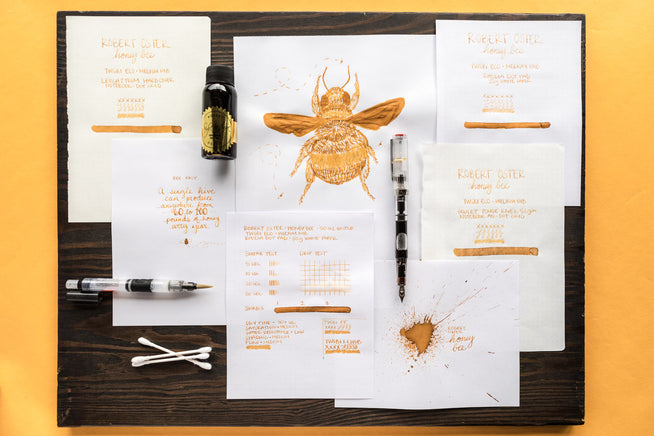 Robert Oster Honey Bee fountain pen ink, swab, splatter, and drawing on a black and yellow background