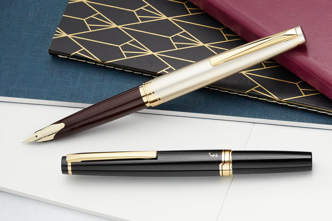 Pilot E95S Fountain Pen black and burgundy/ivory on a Traveler's Notebook on a wooden serving tray