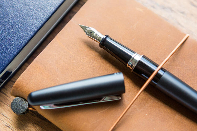 Pilot Metropolitan fountain pen uncapped on brown notebook