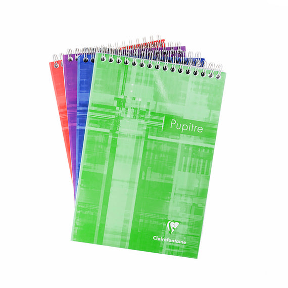Four wirebound notebooks stacked with a green one on top on a white background
