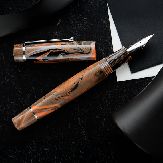 A blue, brown, and orange fountain pen with silver trim and nib, inspired by cave paintings.