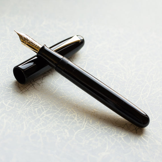 Black fountain pen on a textured white surface