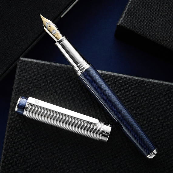 Fountain pen with blue barrel and silver accents on a dark surface